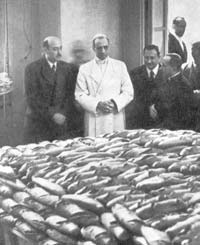 Pius XII looks at the food that the Vatican prepared for war prisoners and refugees